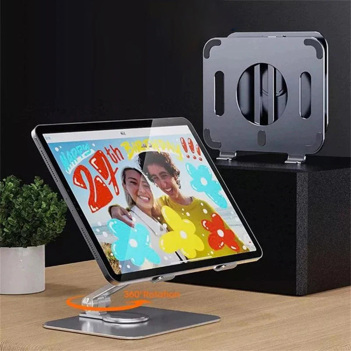 Sammenklappelig og drejelig iPad-holder i aluminium, grå, præsenteret på et bord, 360° justerbarhed, ergonomisk design og holdbar.