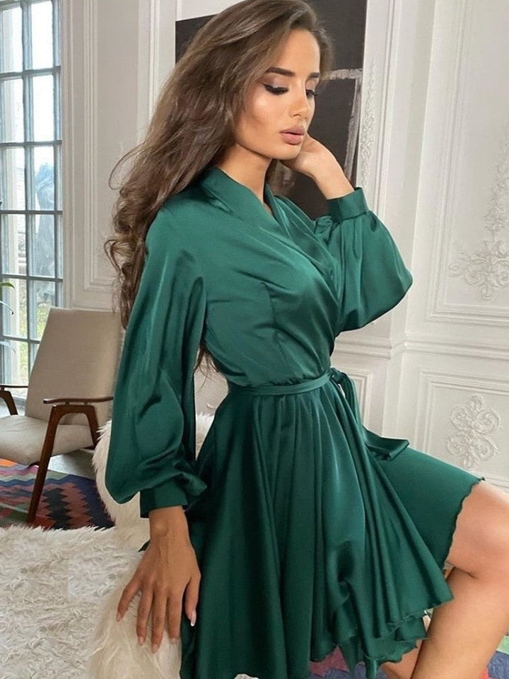 Elegant damefestkjole i satinlook, knælang, stilfuldt snit; fås i flere farver.