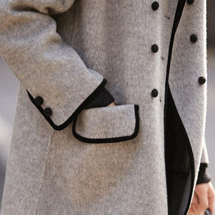 Stilfuld dame lang dobbeltradet vintage uldfrakke i en grå nuance med klassisk design, perfekt til efteråret.
