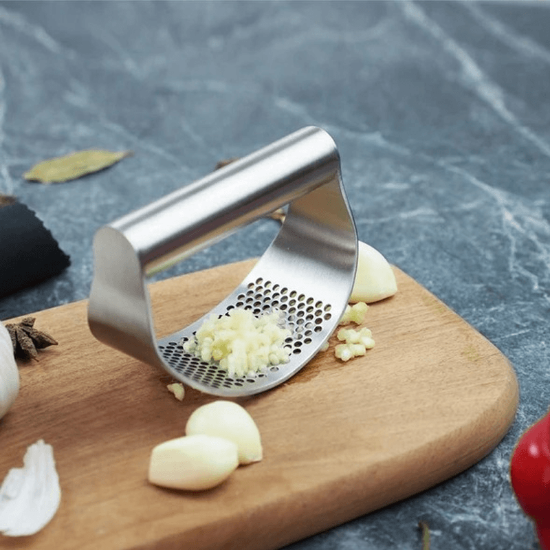 Stilfuld hvidløgspresser i rustfrit stål med buet ergonomisk design til køkkenet, effektiv og holdbar.