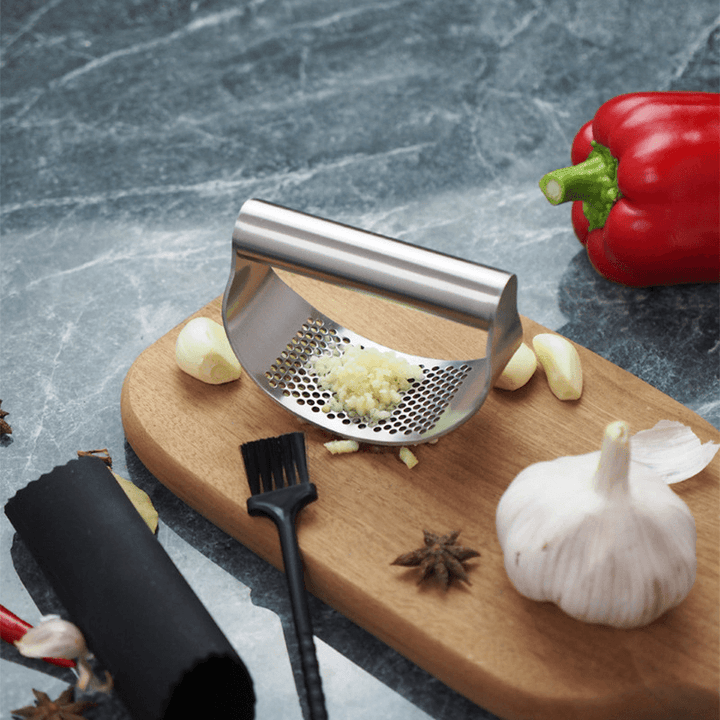 Stilfuld hvidløgspresser i rustfrit stål med buet ergonomisk design til køkkenet, effektiv og holdbar.