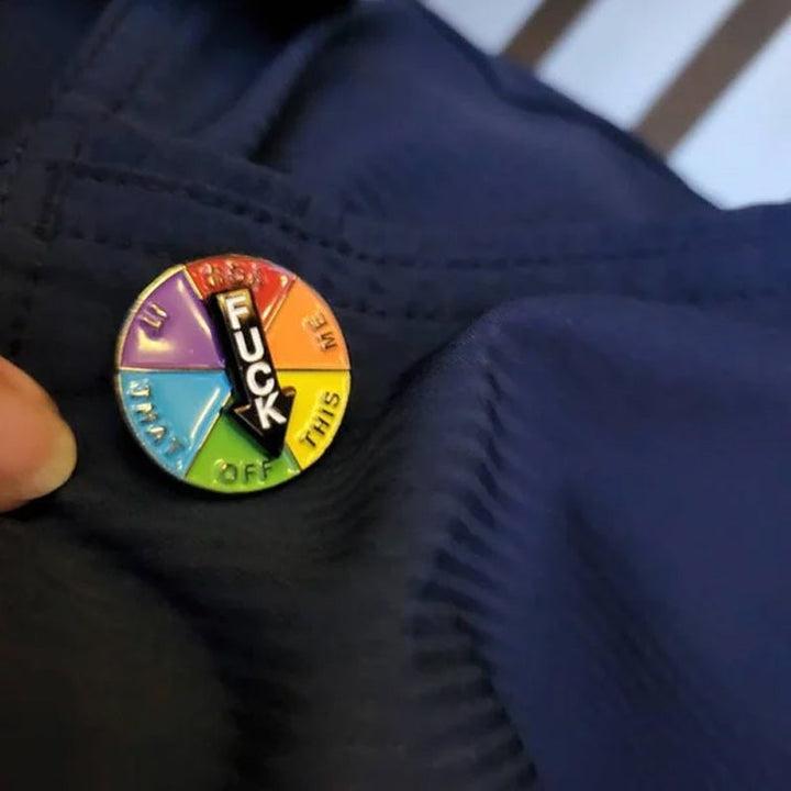 Unik emalje-broche med syv udtryk, lyse farver, lille størrelse, perfekt som tøjtilbehør til jakke eller taske.