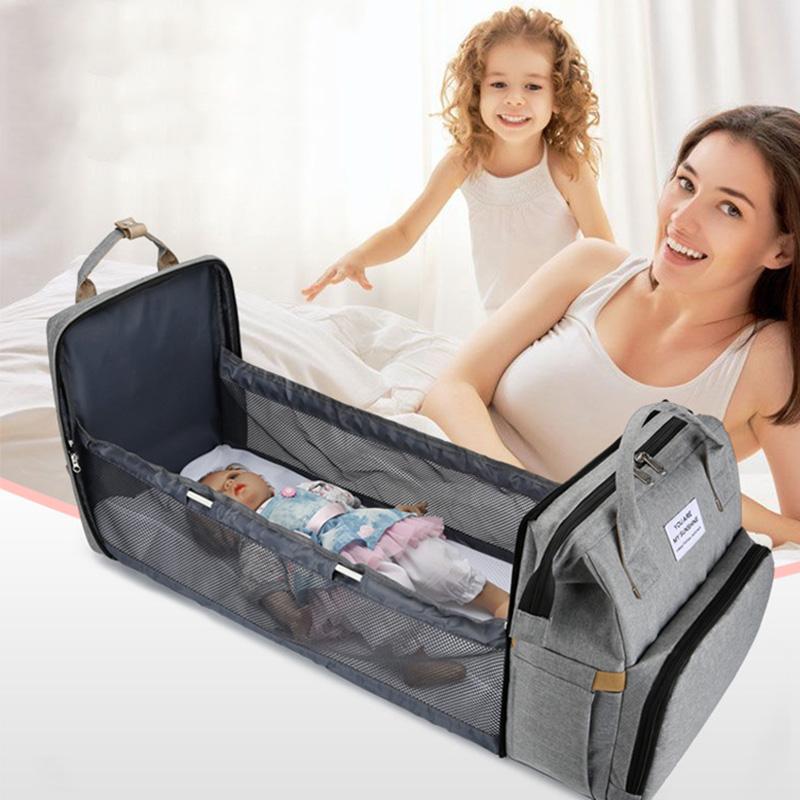 Unisex babyplejerep med seng, mange lommer til babyudstyr, foldet sammen, gråt Oxford-stof.