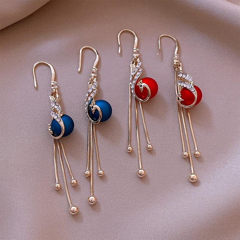 Elegante påfugl-øreringe til kvinder, blå eller rød perle, guldfarvet metal, elegant design, accessory stil.