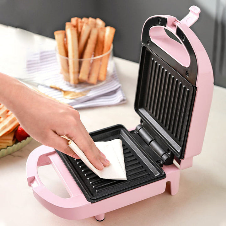 Pink og rød multifunktionel morgenmadsgrill, kompakt og pladsbesparende til køkkenet, velegnet til stegning og grillning