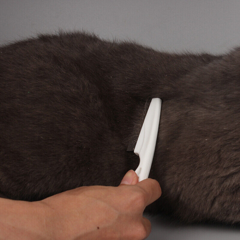 Hvid ergonomisk kæledyrskam med afrundede tænder, sikkert og effektivt pelsplejeværktøj.