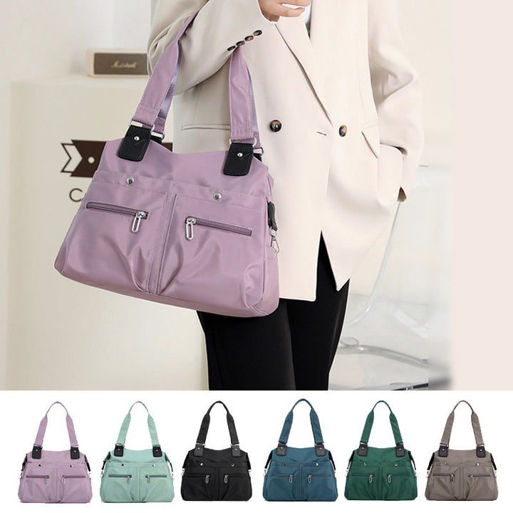 Vandtæt nylonhåndtaske til damer, sort farve, med flere lynlåslommer, justerbar skulderrem og et stilfuldt design.