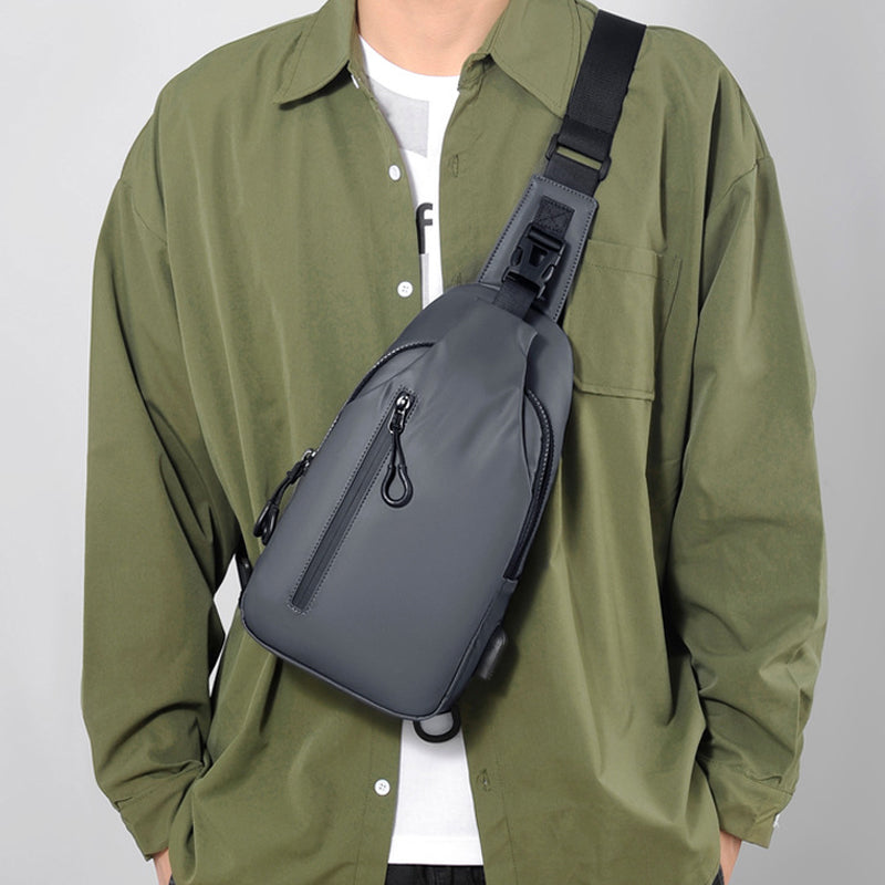 Vandtæt unisex brysttaske med USB-port, sort, blå, grå, justerbar rem, flere lommer, stilfuldt design.