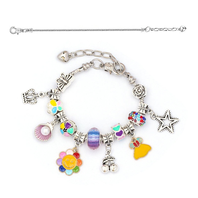 Farverigt DIY-armbåndssæt til børn, indeholder flerfarvede perler og vedhæng til kreative smykkedesigns.