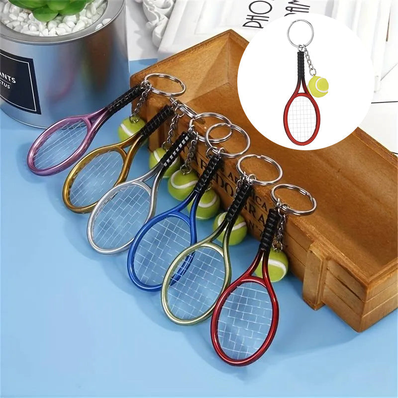 Farverig mini tennisracket nøglering i seks farver: rød, grøn, lilla, sølv, guld og blå.