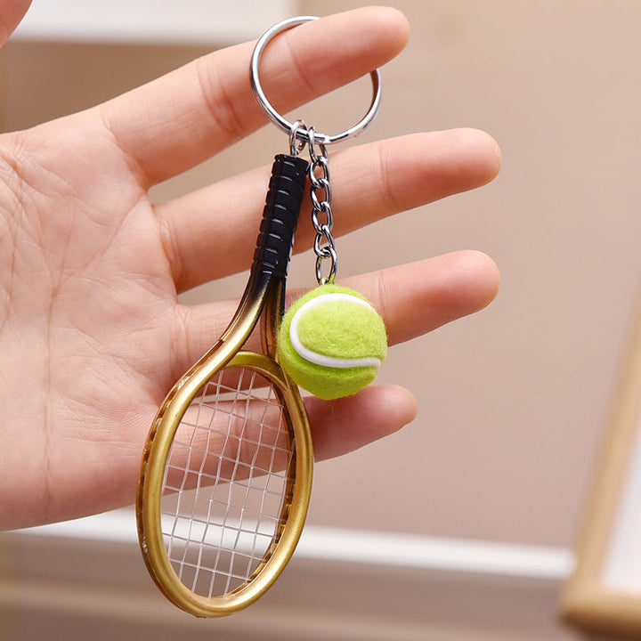 Farverig mini tennisracket nøglering i seks farver: rød, grøn, lilla, sølv, guld og blå.