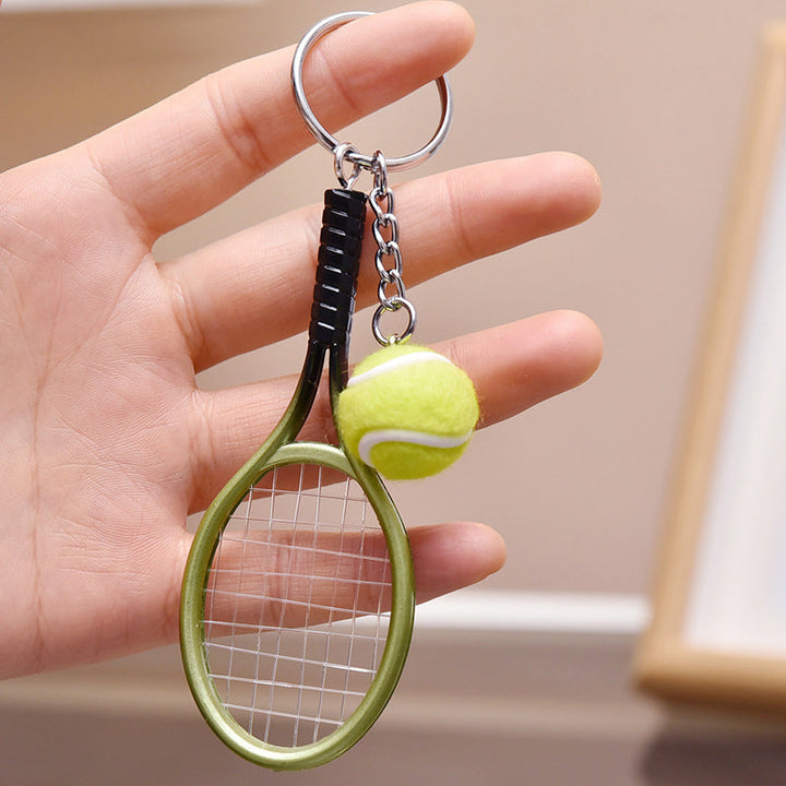 Farverig mini tennisracket nøglering i seks farver: rød, grøn, lilla, sølv, guld og blå.