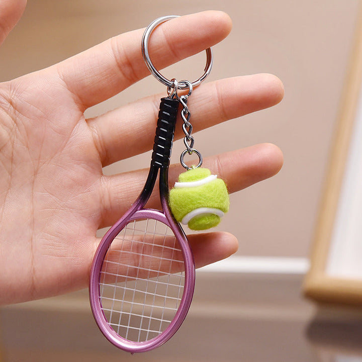 Farverig mini tennisracket nøglering i seks farver: rød, grøn, lilla, sølv, guld og blå.