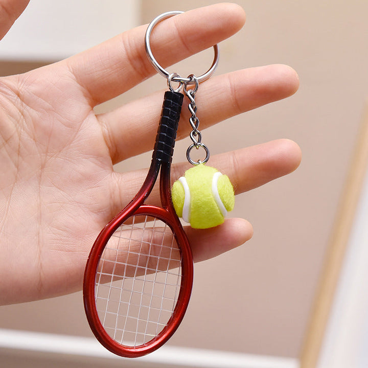 Farverig mini tennisracket nøglering i seks farver: rød, grøn, lilla, sølv, guld og blå.