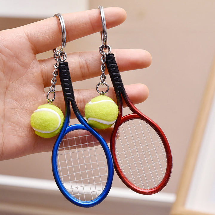 Farverig mini tennisracket nøglering i seks farver: rød, grøn, lilla, sølv, guld og blå.