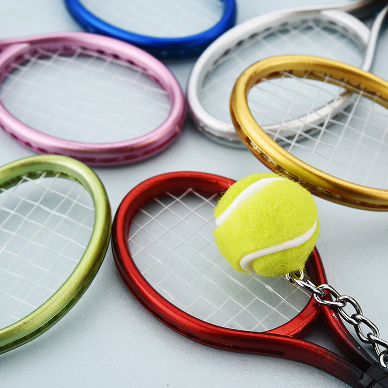 Farverig mini tennisracket nøglering i seks farver: rød, grøn, lilla, sølv, guld og blå.