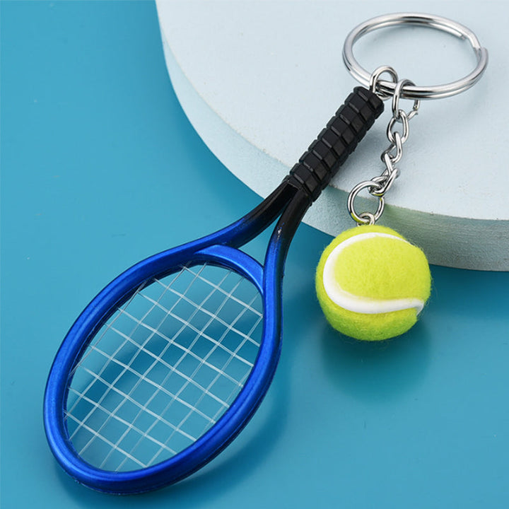 Farverig mini tennisracket nøglering i seks farver: rød, grøn, lilla, sølv, guld og blå.