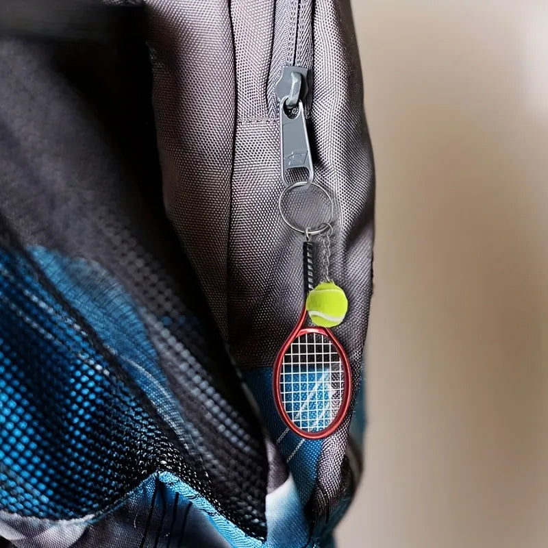 Farverig mini tennisracket nøglering i seks farver: rød, grøn, lilla, sølv, guld og blå.