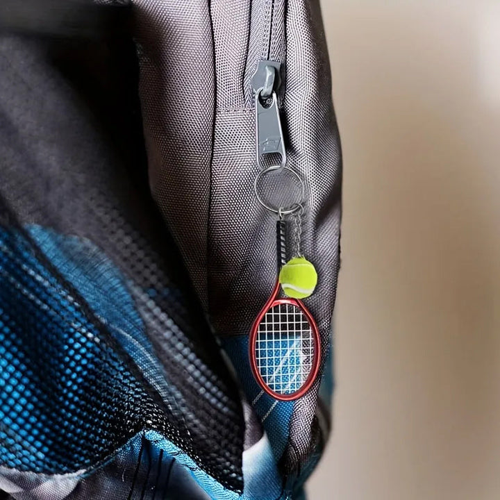 Farverig mini tennisracket nøglering i seks farver: rød, grøn, lilla, sølv, guld og blå.