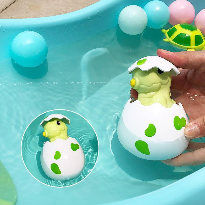 Farverigt babylegetøj til badetid, med gule andeæg og blå dinosauræg, der bringer glæde i badet.