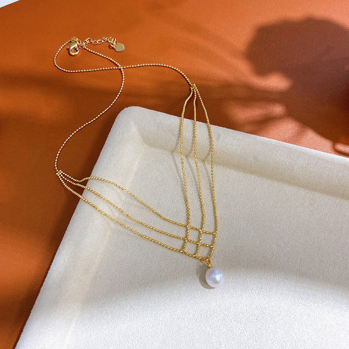Luksuriøs dame kobber perlekæde med perlevedhæng og kors-kæde, elegant design, iøjnefaldende.