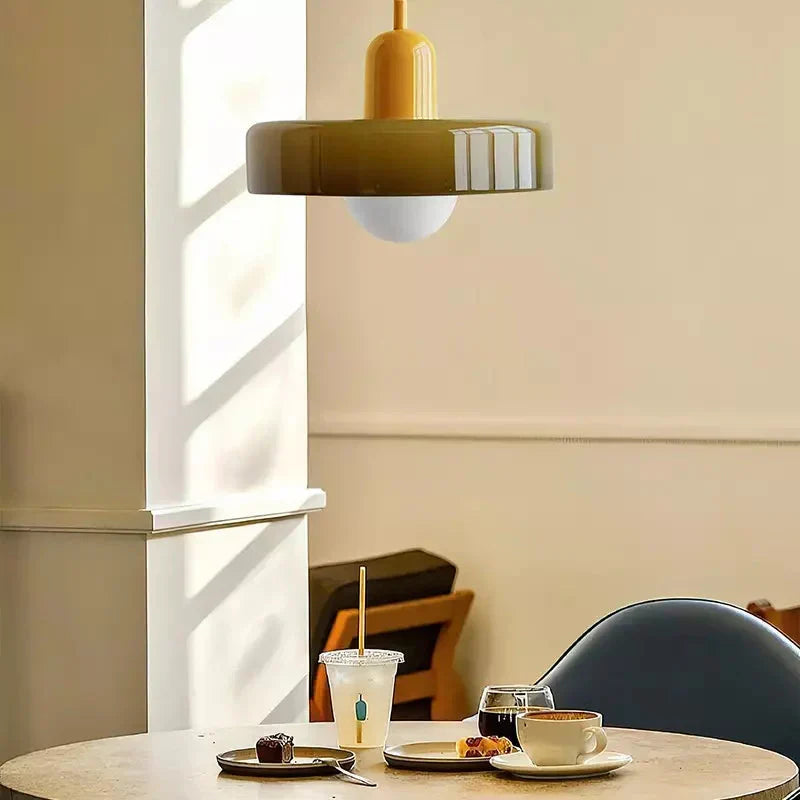 Tre Bauhaus pendellamper i farvet glas i række. Skaber et dramatisk udtryk.