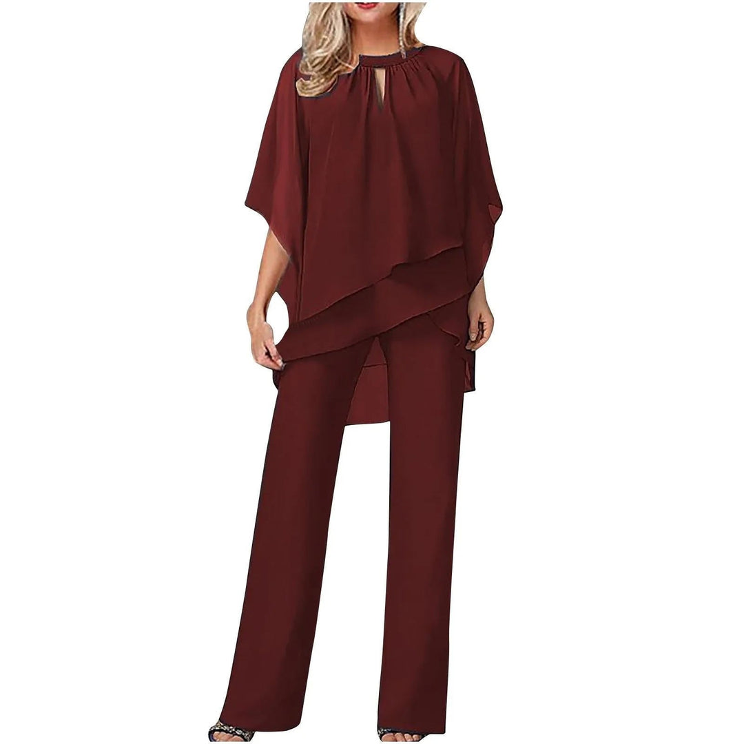 Festlig dame dragtsæt i chiffon med asymmetrisk overdel, bukser og flagermusærmer. Ideel til festtøj.