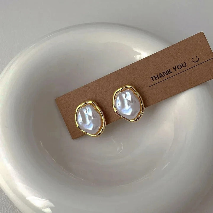 Elegant perleørering med hvid perle og guld detalje til kvinder. Klassisk design perfekt til fest eller hverdag.