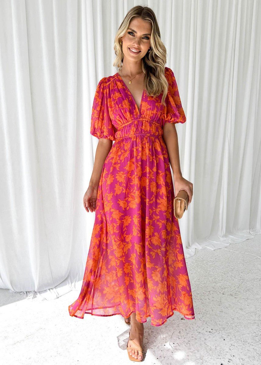 Dame midi kjole i pink og orange med livligt blomsterprint, elegante pufærmer og flatterende V-udskæring.