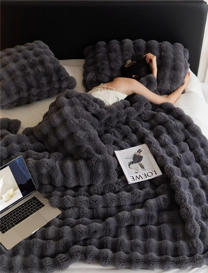 Blødt plys tæppe for hygge og varme, perfekt som sofatæppe til kolde vinteraftener.