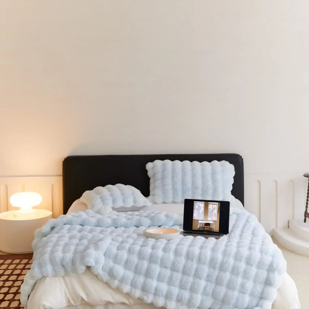 Komfortabelt sofatæppe i blødt plys, designet for maksimal varme og hygge om vinteren.