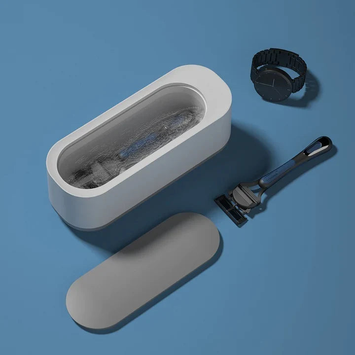 Kompakt PurePulse ultralydsrenser med kurv og låg, klar til effektiv rengøring i hus & have.